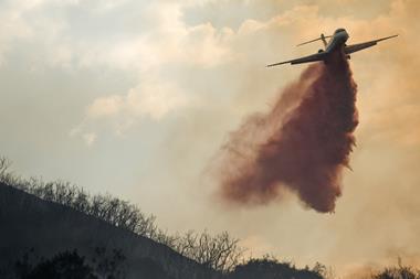 A plane drops fire retardant on a wildfire